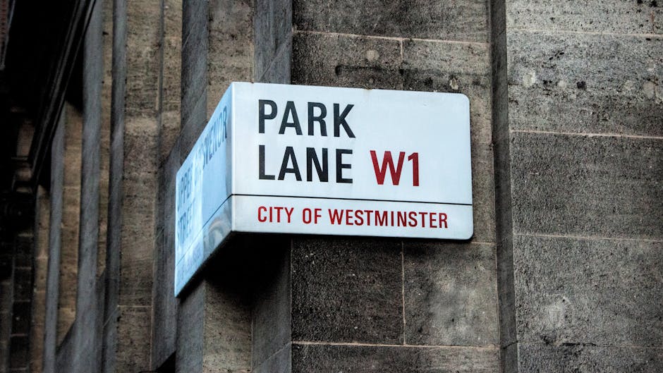 A close-up view of an exterior building wall in Westminster, showing a white rectangular sign with black and red lettering indicating 'Bell Yard WC2', part of the City of Westminster. Below this, ther